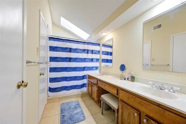 full bathroom featuring a skylight, tile patterned flooring, visible vents, and a sink