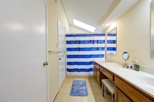 bathroom featuring a skylight, double vanity, curtained shower, a sink, and tile patterned floors