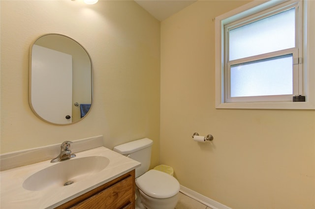 bathroom with baseboards, vanity, and toilet