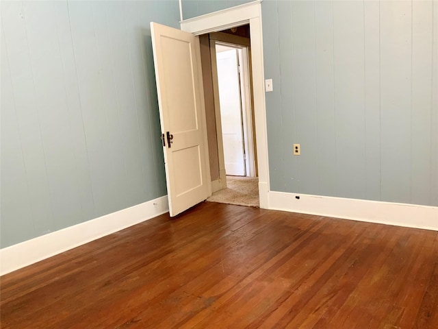 spare room with wood finished floors and baseboards