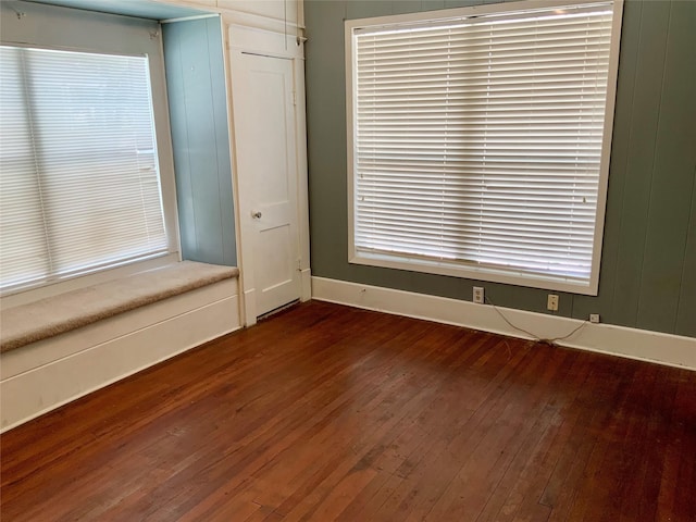 empty room featuring baseboards and wood finished floors