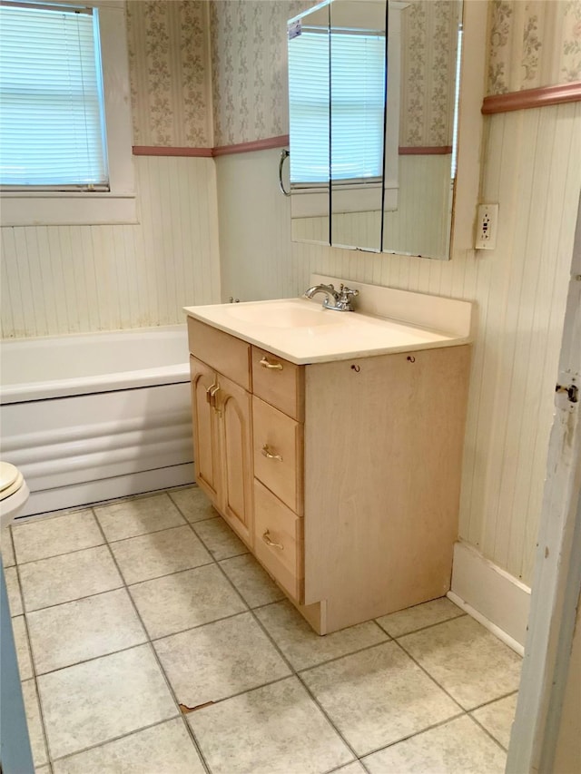 full bathroom with tile patterned floors, a wainscoted wall, and wallpapered walls