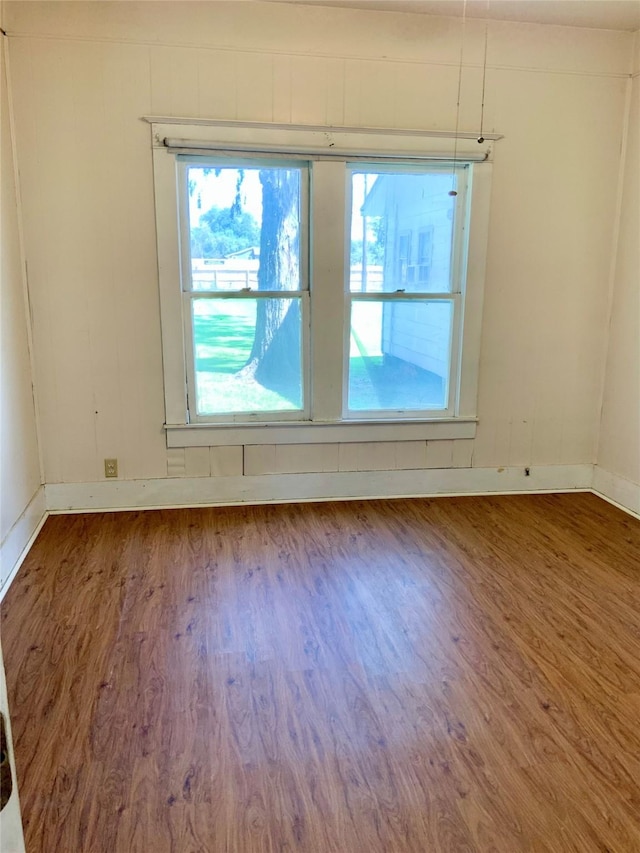 unfurnished room with baseboards and wood finished floors