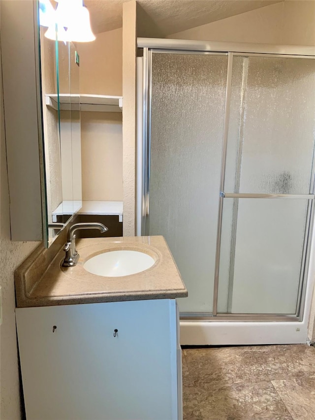 bathroom with a shower with shower door and vanity