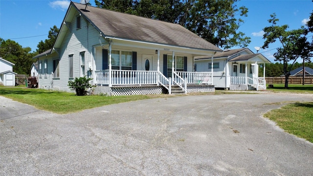 view of front of house featuring a porch, a front yard, crawl space, and roof with shingles