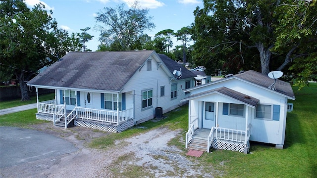 bungalow featuring driveway, a porch, roof with shingles, and a front yard