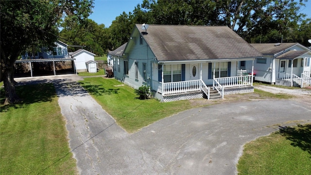 view of front of property with covered porch, an outdoor structure, driveway, a storage unit, and a front lawn