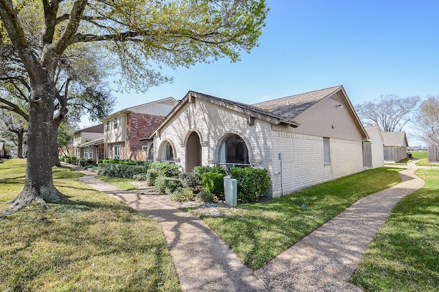 view of property exterior with a yard and brick siding