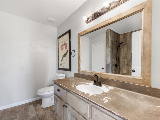 full bath featuring toilet, visible vents, vanity, baseboards, and tiled shower