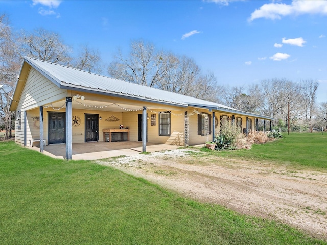 view of front facade featuring a front yard, metal roof, and dirt driveway