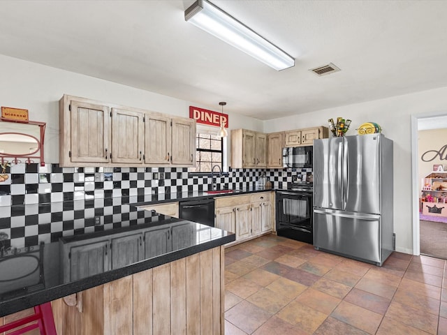 kitchen featuring dark countertops, visible vents, a peninsula, and black appliances