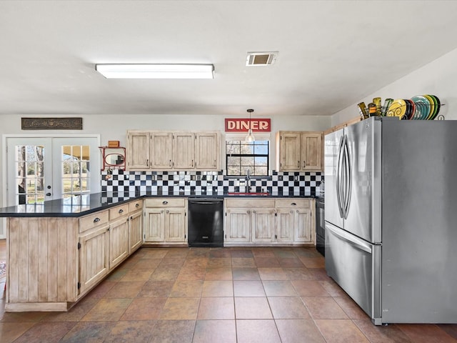 kitchen featuring black dishwasher, dark countertops, visible vents, freestanding refrigerator, and a sink