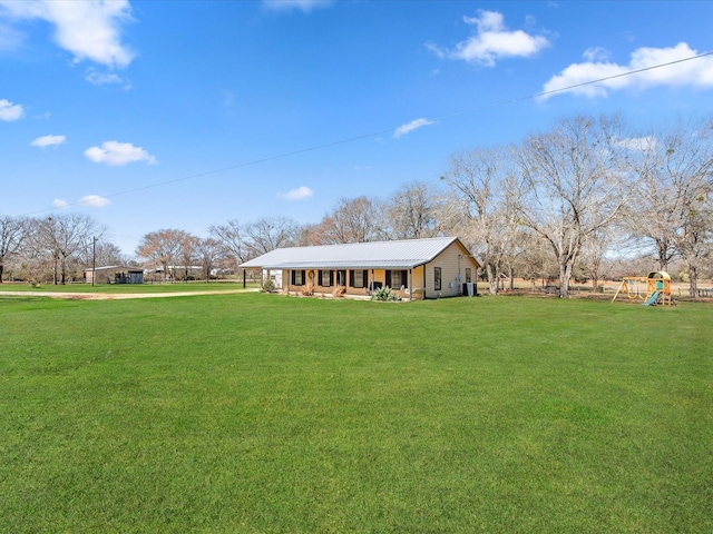 view of front of home with a carport, playground community, metal roof, and a front lawn