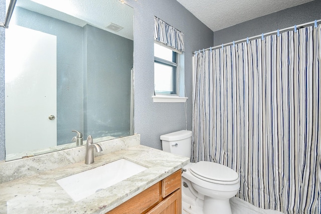 bathroom featuring visible vents, vanity, toilet, and a textured ceiling