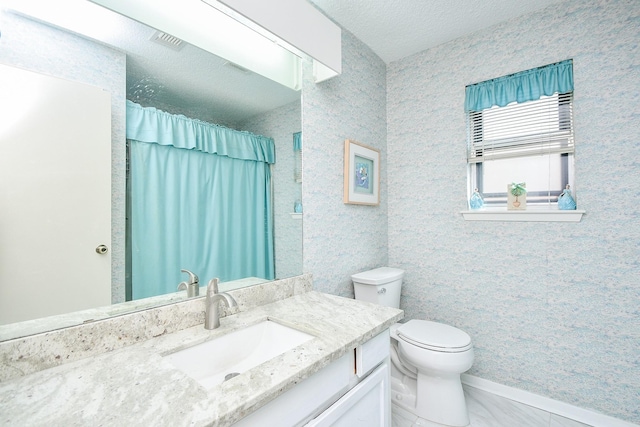 bathroom with visible vents, toilet, vanity, a textured ceiling, and baseboards