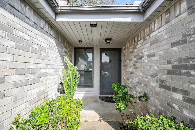 view of exterior entry with brick siding