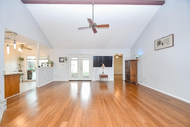 unfurnished living room featuring french doors, plenty of natural light, wood finished floors, and a ceiling fan