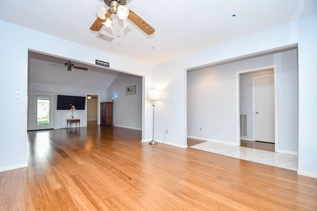 unfurnished living room with light wood-style flooring, visible vents, and a textured ceiling