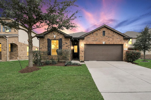 single story home featuring driveway, a garage, a lawn, and brick siding