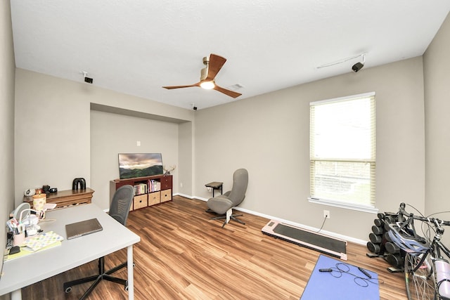 home office with a ceiling fan, baseboards, and wood finished floors