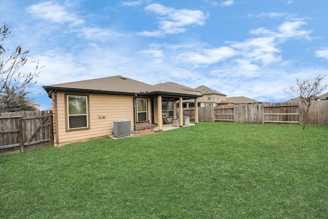 rear view of house with a fenced backyard and a yard