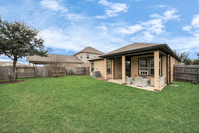 rear view of property with a patio area, a yard, and a fenced backyard