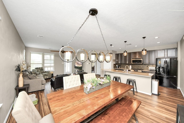 dining room featuring recessed lighting, baseboards, visible vents, and light wood finished floors