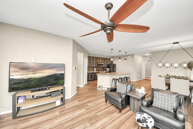 living area with recessed lighting, baseboards, ceiling fan, and light wood finished floors