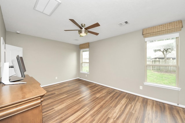 spare room featuring visible vents, ceiling fan, baseboards, and wood finished floors