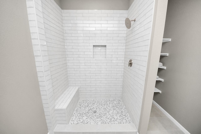 full bathroom featuring a stall shower, tile patterned floors, and baseboards