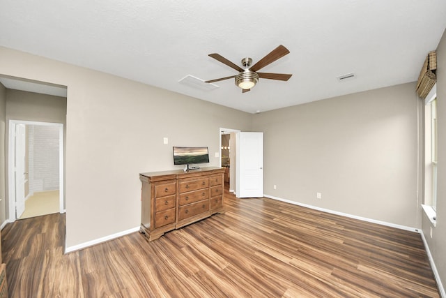 bedroom featuring a ceiling fan, visible vents, baseboards, and wood finished floors