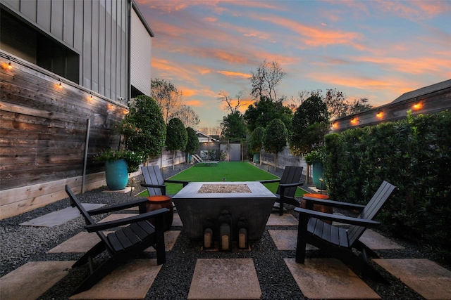 patio terrace at dusk featuring fence and a fire pit