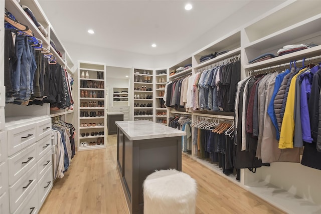 walk in closet with light wood-style floors