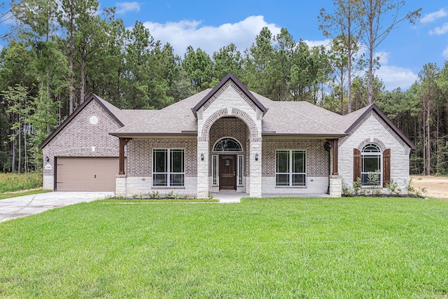 french provincial home featuring driveway, a shingled roof, a front lawn, and brick siding