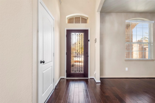 entrance foyer with dark wood-style flooring and baseboards