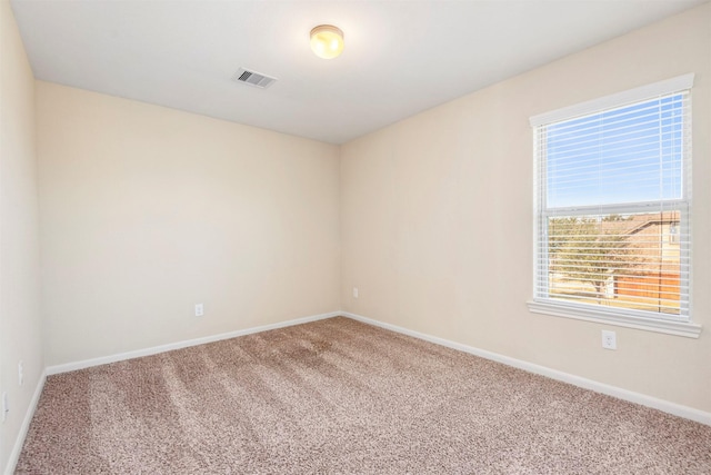 carpeted empty room featuring visible vents and baseboards