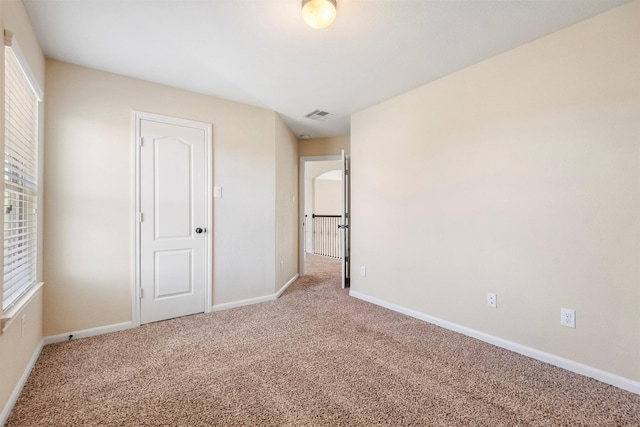 unfurnished bedroom featuring visible vents, baseboards, and carpet flooring