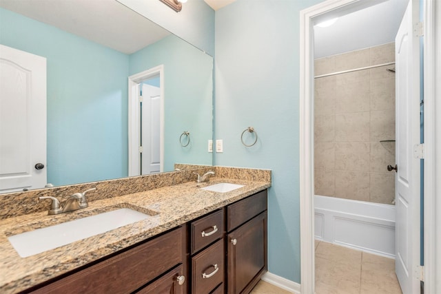 full bath featuring shower / bathtub combination, double vanity, a sink, and baseboards