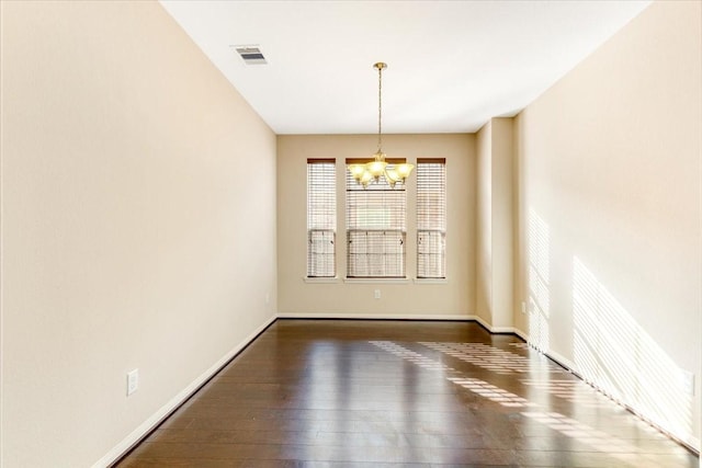 empty room featuring dark wood-style floors, baseboards, visible vents, and an inviting chandelier