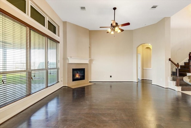 living area featuring stairs, visible vents, dark wood-type flooring, and a tile fireplace