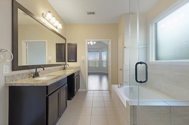 bathroom with a bath, visible vents, a sink, and tile patterned floors