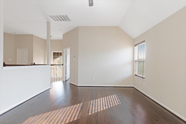 unfurnished room featuring ceiling fan, visible vents, baseboards, vaulted ceiling, and dark wood finished floors