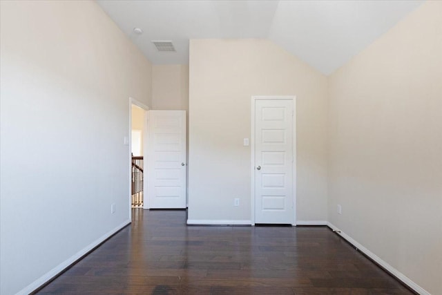 empty room featuring dark wood-style floors, visible vents, high vaulted ceiling, and baseboards