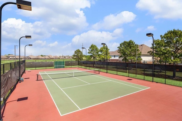 view of tennis court with community basketball court and fence