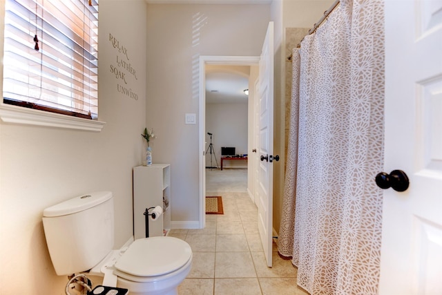 bathroom with baseboards, a shower with curtain, toilet, and tile patterned floors