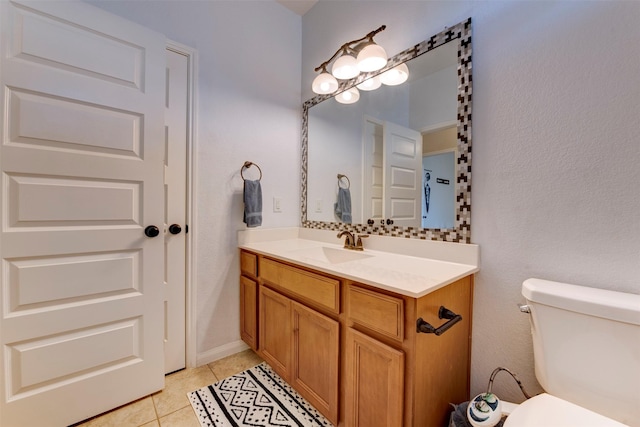 half bathroom featuring tile patterned flooring, vanity, and toilet