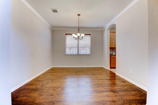 unfurnished room with visible vents, arched walkways, ornamental molding, wood finished floors, and a chandelier