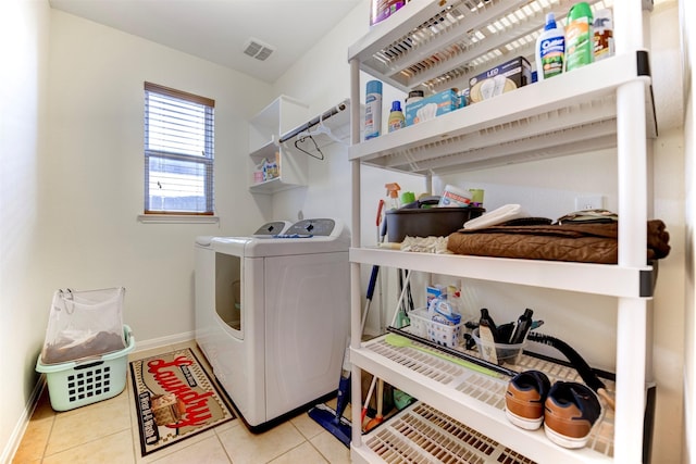 clothes washing area with light tile patterned floors, laundry area, visible vents, baseboards, and independent washer and dryer