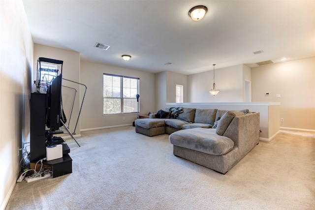 living area with light colored carpet, visible vents, and baseboards