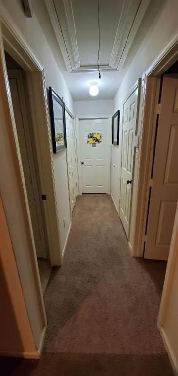 corridor with carpet, attic access, and baseboards